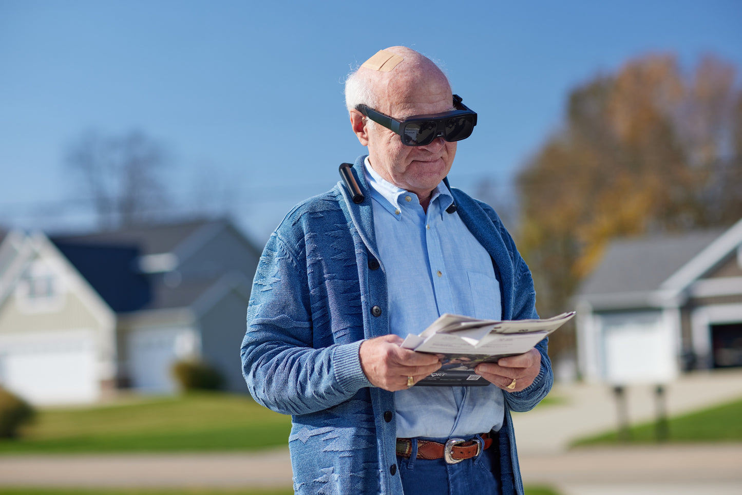 eSight Go Electronic Glasses is built for all-day use: an old man reading a morning newspaper