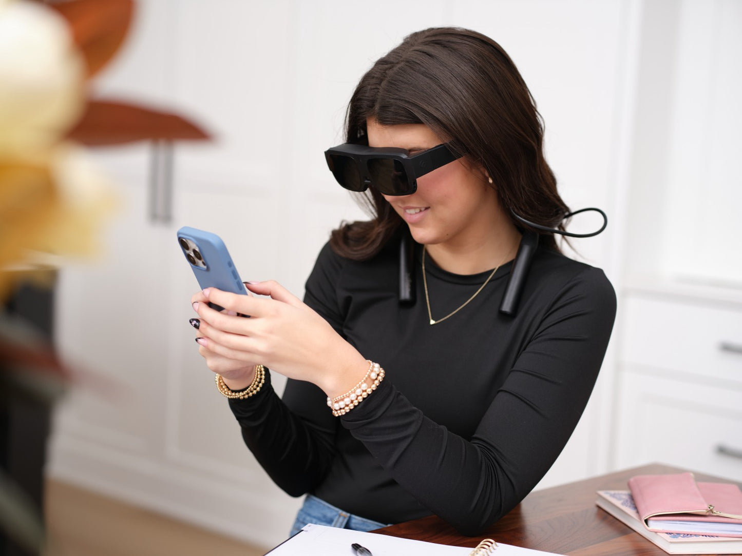 eSight Go Glasses helping a girl to serve the internet on mobile.