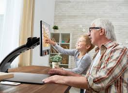 A person using the MagniLink S Premium 2 Pro, a portable video magnifier, to view enlarged content on a monitor in a classroom.