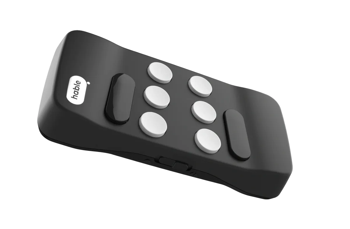 A close-up of a Floridareading Hable Easy remote control. The remote is black with white buttons and the Hable logo on the top. The remote is angled slightly to show its curved shape.