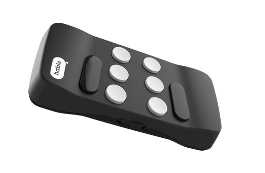 A close-up of a Floridareading Hable Easy remote control. The remote is black with white buttons and the Hable logo on the top. The remote is angled slightly to show its curved shape.