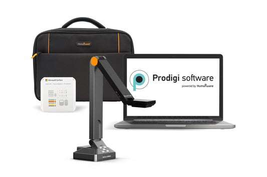 A black laptop displaying the Prodigi software logo, powered by Humanware. A black USB-powered video camera with a flexible arm is positioned in front of the laptop. A carrying case and a small white box with the Microsoft Surface logo are also included.