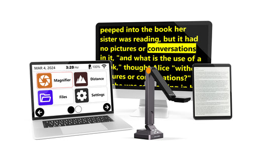 A laptop displaying the Prodigi software logo, powered by Humanware, is connected to a USB-powered video camera with a flexible arm. A tablet and a second monitor are also connected to the laptop. The laptop screen shows text from a book, and the tablet displays the same text.