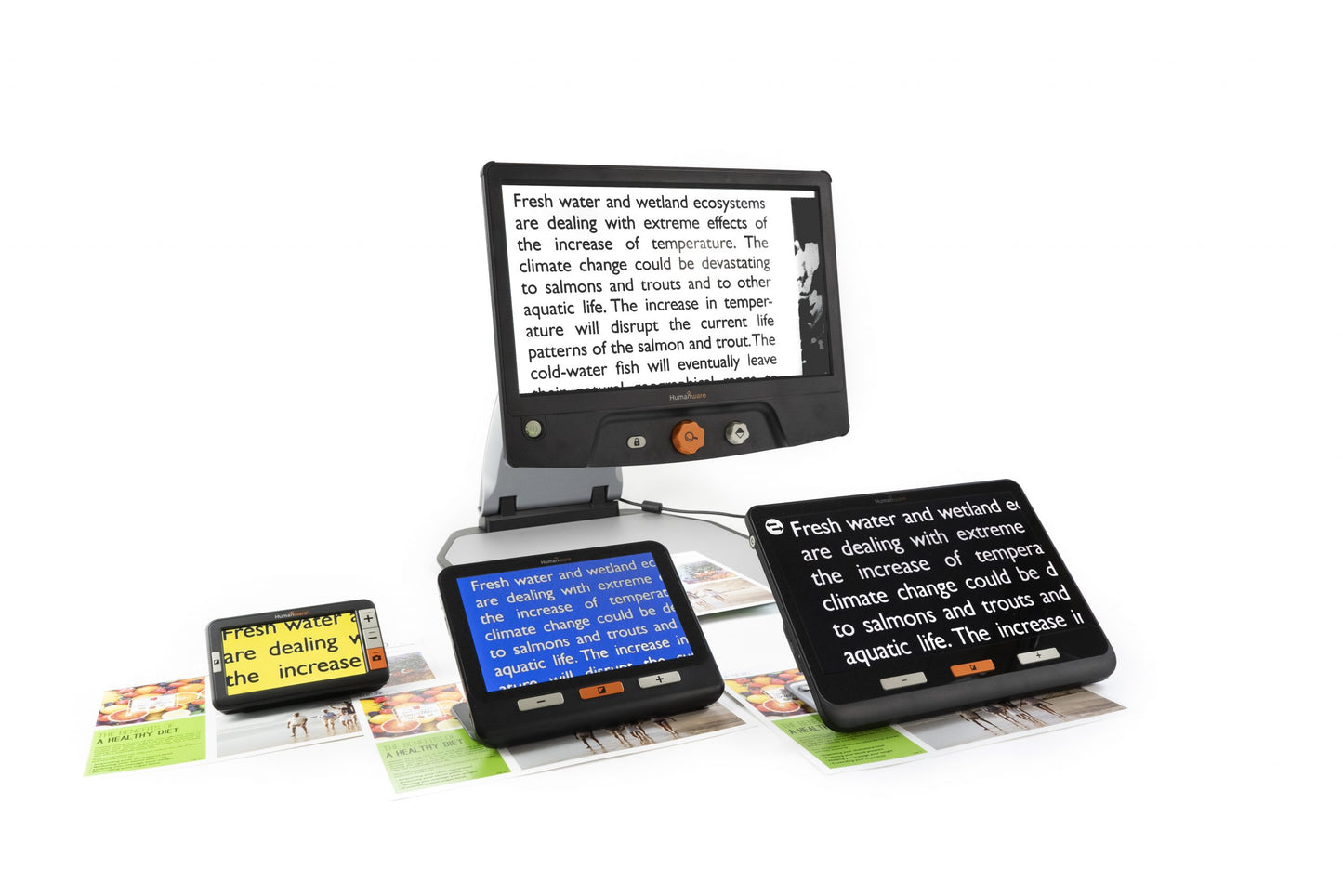 A desktop magnifier with multiple screens, magnifying text from a book. The device has a Humanware logo and controls for zooming and adjusting brightness.