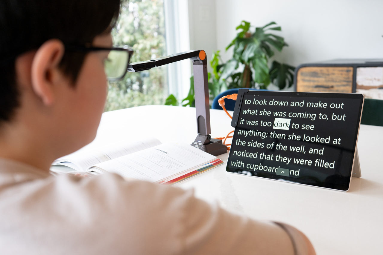 Student reading text on a tablet with the Prodigi Software Complete Kit setup, including camera and magnification.